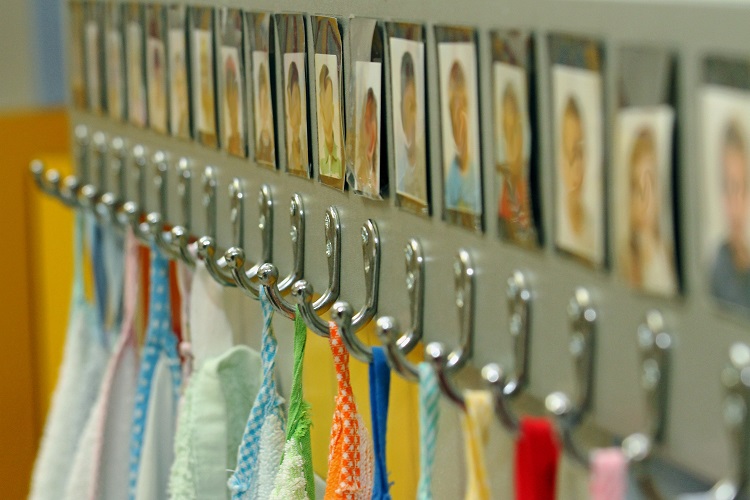 Hooks with children's pictures above to help them identify which hooks belongs to them